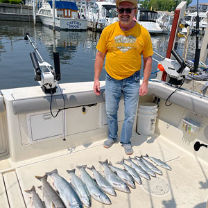 Client posing on the charter boat with the several fish he caught
