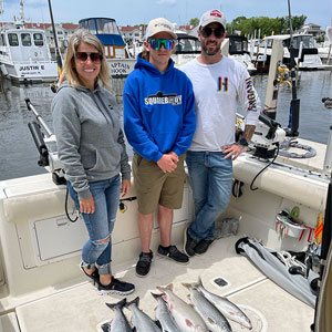 Group of 3 clients posing on the charter boat with the lake fish they caught