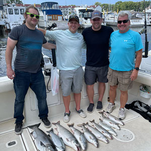 Group of 4 clients posing on the charter boat with the lake fish they caught