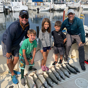 Group of 5 clients posing on the charter boat with the lake fish they caught