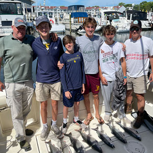 Group of 6 clients posing on the charter boat with the lake fish they caught