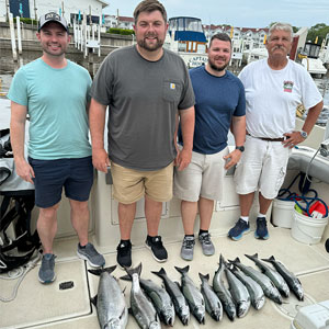 Group of 4 clients posing on the charter boat with the lake fish they caught