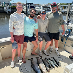Group of 4 clients posing on the charter boat with the lake fish they caught